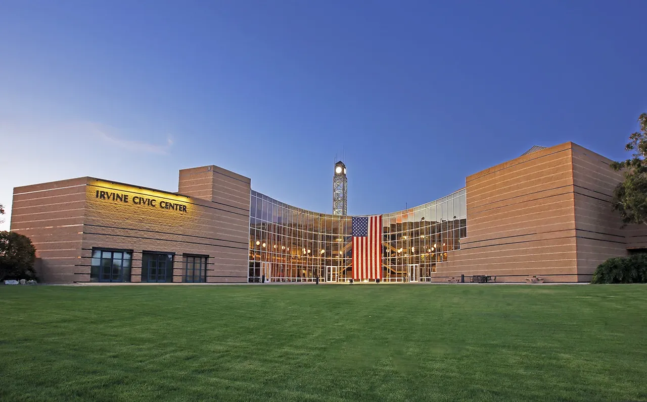 Irvine City Hall building displays American flag.